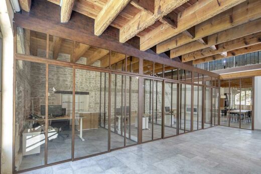 Une verrière en aluminium de couleur rouille dans une ancienne grange